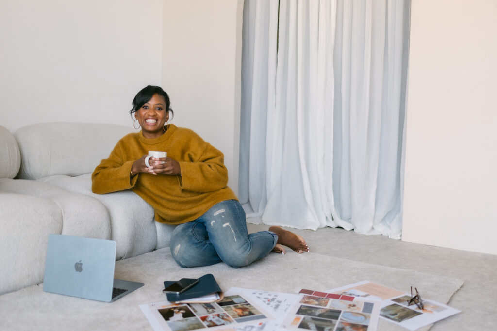 Image of owner of Perfectly Planned 4 You, Cherelle, sitting with a cup of tea with her laptop in front of her